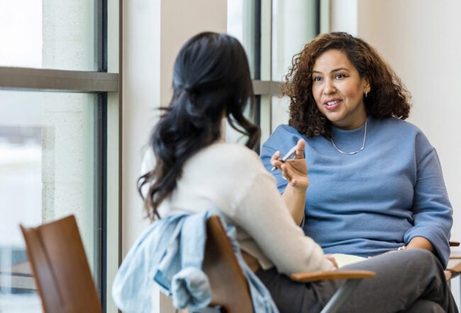 Therapist talking to a client in a mental health clinic. Why are private equity firms buying health care facilities?
